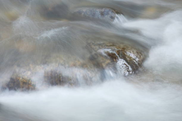 blurry water flowing on the rock and wave splashing - indirection imagens e fotografias de stock