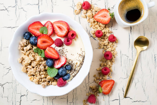 istock Granola with berries, yoghurt and coffee for breakfast. Cereal oats with strawberries, blueberries and raspberries for healthy eating 1049372684