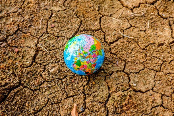 a terra é colocada sobre o solo seco conceito de aquecimento global. - global warming cracked dirt earth - fotografias e filmes do acervo