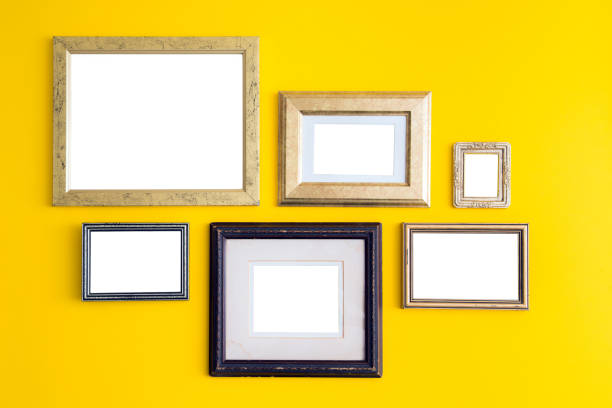 istock Blank empty golden, wooden frames on yellow background. 1049376806