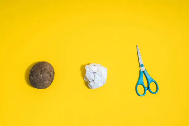 Photo of Rock, paper, scissors concept. Choice, decision making. Top above view on yellow background
