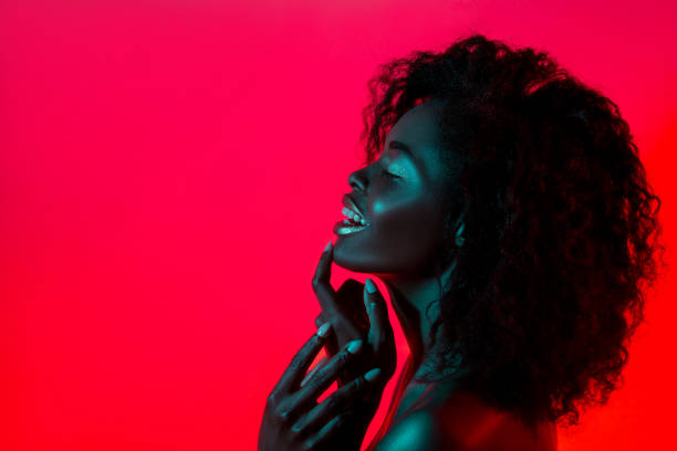 カラフルな明るいライト スタジオでポーズでファッション性の高いモデルの女性 - african descent women american culture human hair ストックフォトと画像