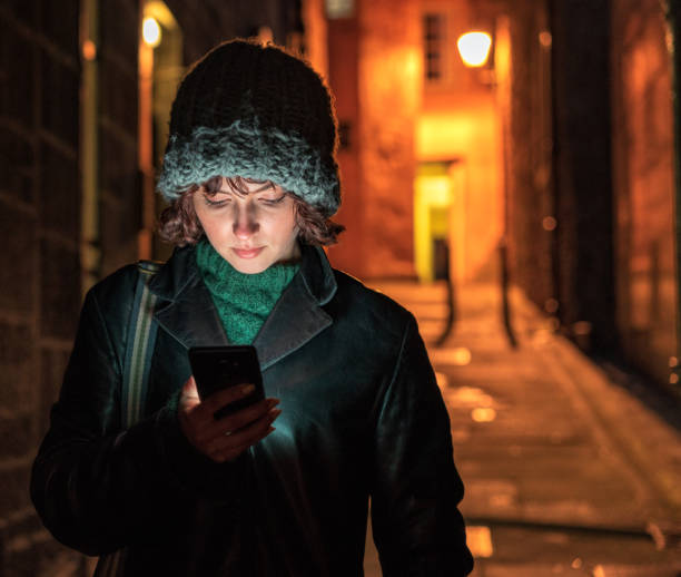 istock Woman checkng her phone alone at night 1049384342