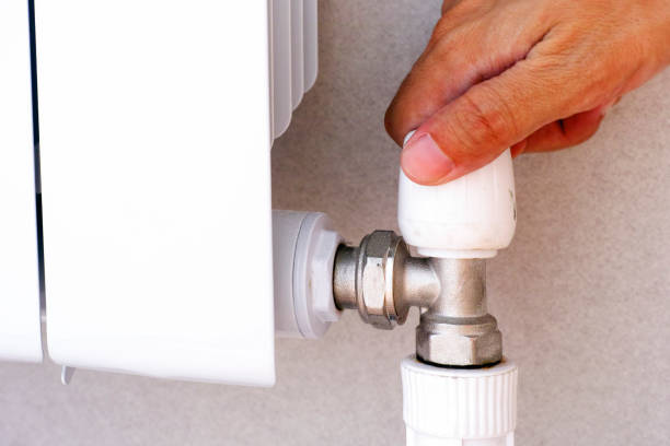 istock Human hand on adjuster of heating radiator. 1049384652