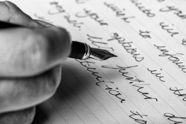 Hand writes words with a fountain pen on paper stock photo