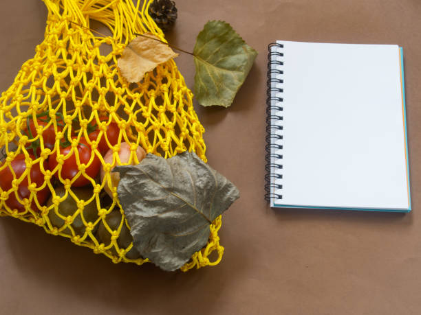 istock Yellow bag with vegetables on brown background 1049392924