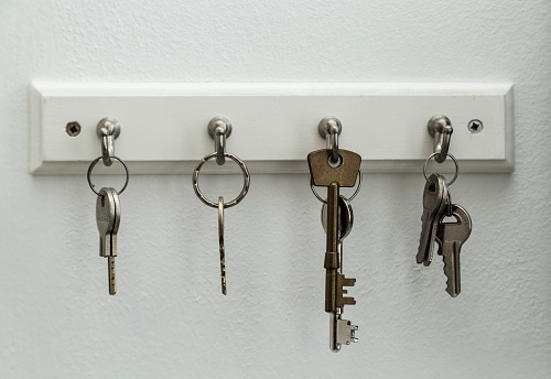 Close-up shot of woman's hand using key to unlock doors. Grey modern design house doors, selective focus.