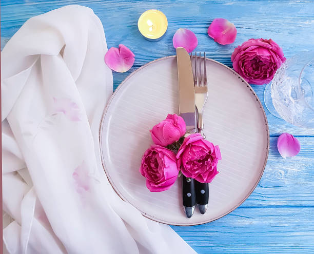 istock flower rose, plate, fork knife, on wooden, candle fire 1049400024