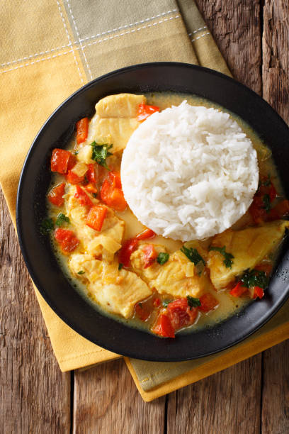istock Fish stew in coconut milk with vegetables and rice close-up. Vertical top view 1049403176