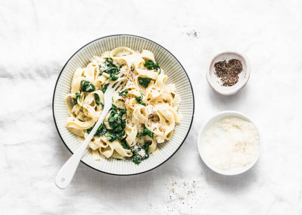 istock Simple fettuccine spinach homemade pasta on light background, top view 1049406482