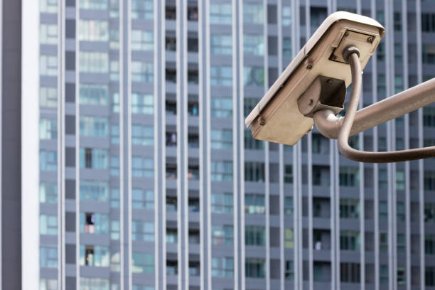 istock outdoor cctv camera with resident tower background. 1049406688