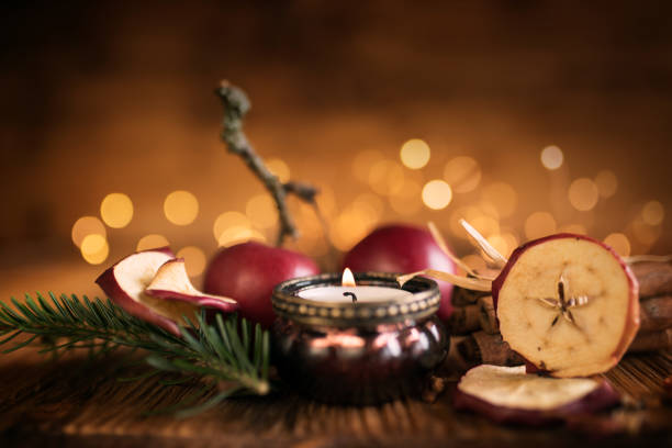 Christmas still life on rustic wooden table with red apples and golden bokeh