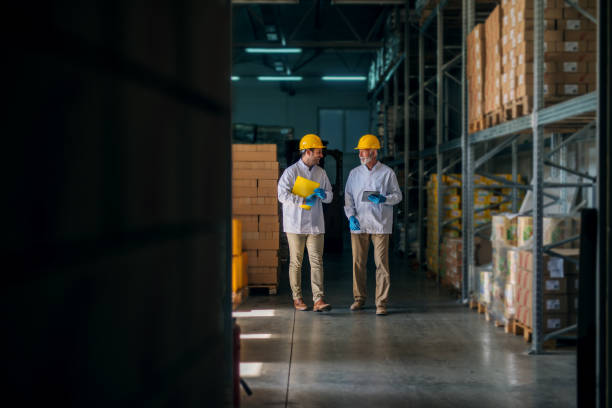istock Cheerful father and son walking through their warehouse and talking about next steps in their business. Holding tablet and documents in their hands. 1049407024
