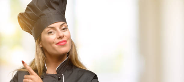 istock Young cook woman pointing away side with finger 1049407700