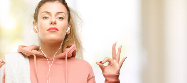 istock Young sport woman wearing workout sweatshirt doing ok sign gesture with both hands expressing meditation and relaxation 1049410034
