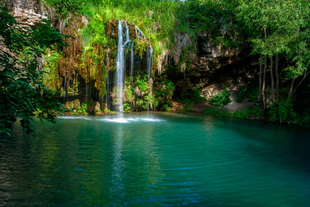 istock Waterfall and a beautiful lagoon lake for relaxing in the summer forest. 1049412122