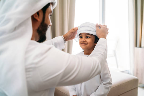 istock Arab man fixing keffiyeh to his son 1049414720