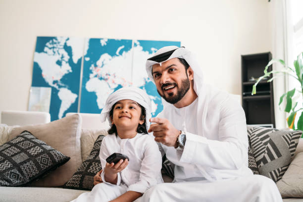 istock Arab man looking TV at home with his son 1049414724