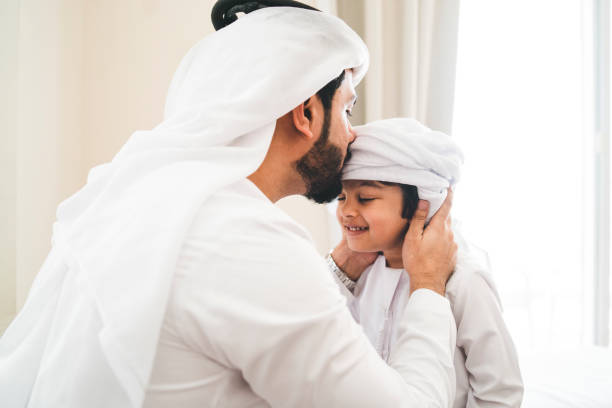 istock Arab man fixing keffiyeh to his son 1049414728