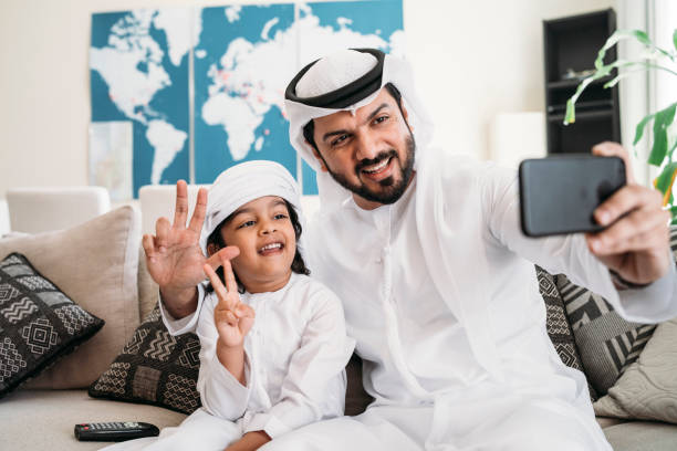 istock Arab man taking a selfie with his son on the sofa at home 1049414742