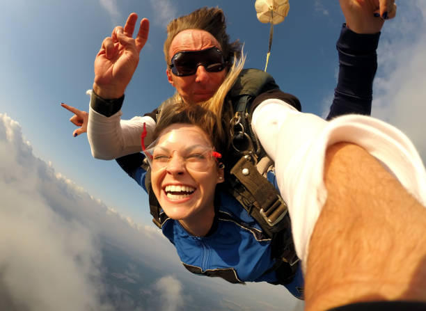 selfie-tandem-fallschirmspringen mit hübschen frau - gleitschirmfliegen stock-fotos und bilder