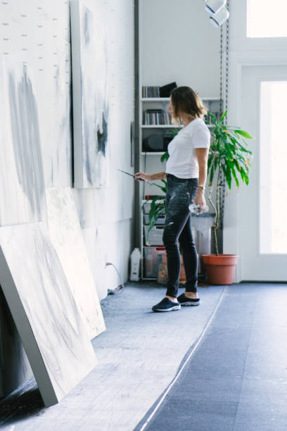 istock Woman painting canvas in art studio 1049450874