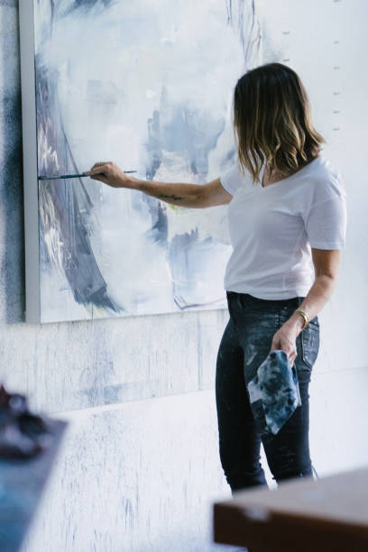istock Woman painting canvas in art studio 1049451878