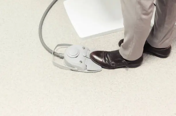 Close up image of dentist stepping on mechanical pedal at his office.