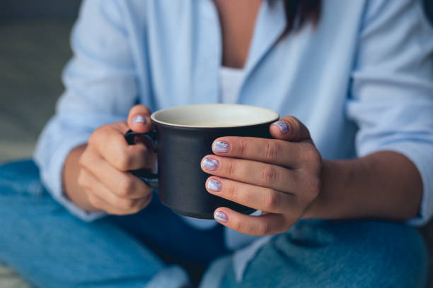 istock Cute girl with a beautiful manicure drinking coffee 1049458192