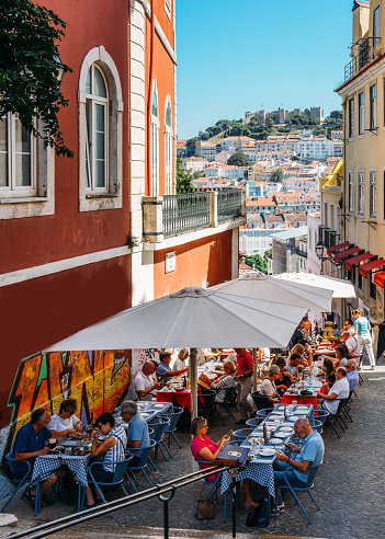 Lisbon, Portugal - Oct 3, 2018: Outdoor cafe on the old streets of Alfama, Lisbon overlooking Castelo Sao Jorge and Baixa
