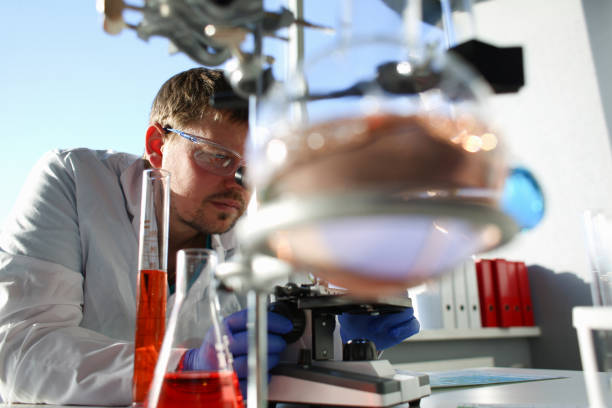 istock Portrait of a young chemist looking in binocular 1049461848