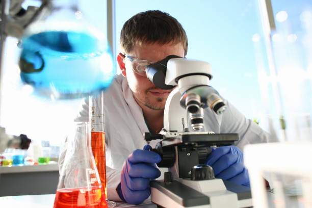 istock Portrait of a young chemist looking in binocular 1049461856
