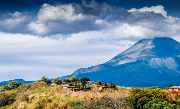 beautiful view of the volcano of colima with green vegetation and a blue sky stock photo