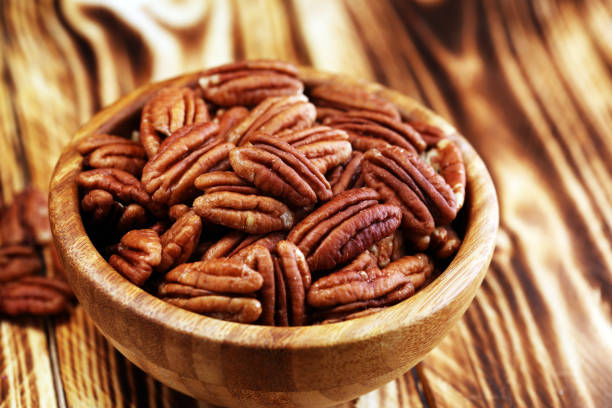istock Pecan nuts on a table and pecan nuts in bowl 1049464930