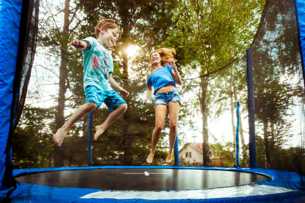 monoparentales que se divierten con su hijo en trampolín - trampolín artículos deportivos fotografías e imágenes de stock