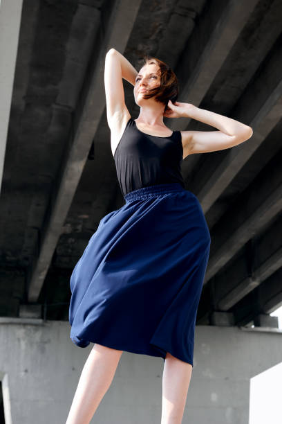 istock young girl posing under the bridge, dressed in black, modern architecture 1049468654