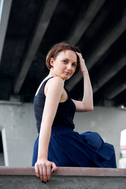istock young girl posing under the bridge, dressed in black, modern architecture 1049468966