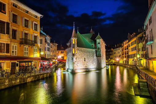 Historical Old Town of Annecy with Palais de l’Isle on a river island, France, illuminated at night