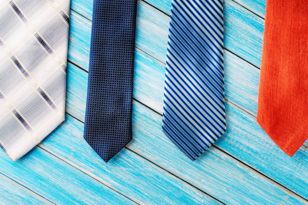 istock four different colored ties in row on wooden blue background 1049472608