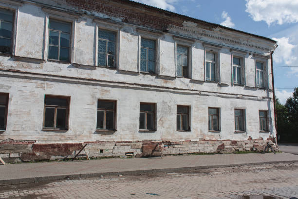 istock old brick two-storey house with broken plaster near the pavement 1049480314
