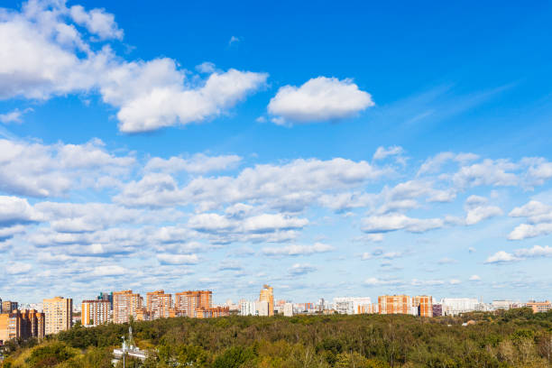 istock white clouds in blue sky over houses and park 1049483522
