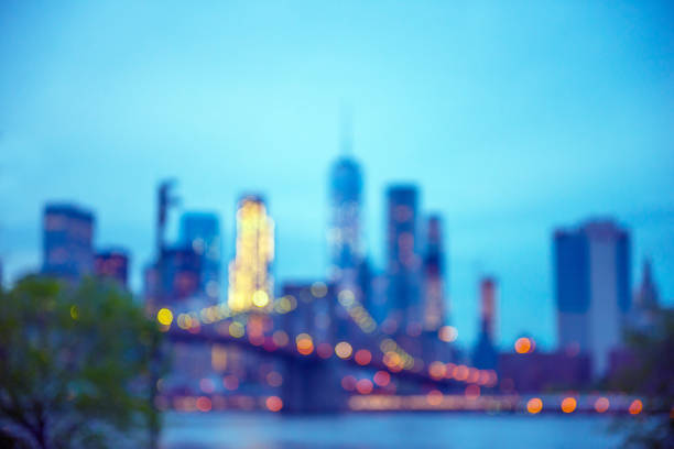 Defocused Background Photograph of NYC Skyline at Dusk This is a defocused background photograph of the Manhattan NYC Skyline with the Freedom Tower and Brooklyn Bridge at dusk. new york city skyline new york state night stock pictures, royalty-free photos & images