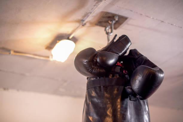 istock Boxing Glove and Punching Bag in Foreground 1049489586