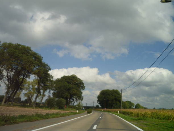 istock Sunny September country ride cloudscape 1049493542