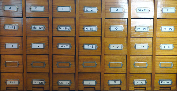 Catalog for catalog cards in library. Wooden catalog in library, with letters on the box, front view