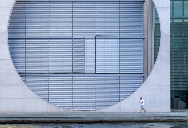 istock Man Jogging By Modern Building In City 1049497258