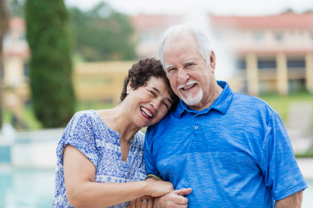 istock Senior Hispanic couple standing by swimming pool 1049497916