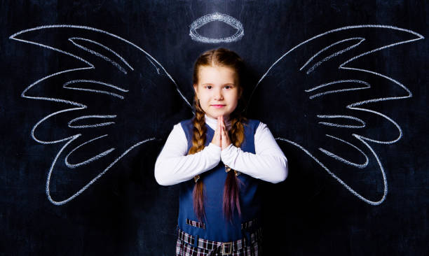 écolière contre le tableau noir, avec des ailes d’ange dessiné - artificial wing photos photos et images de collection