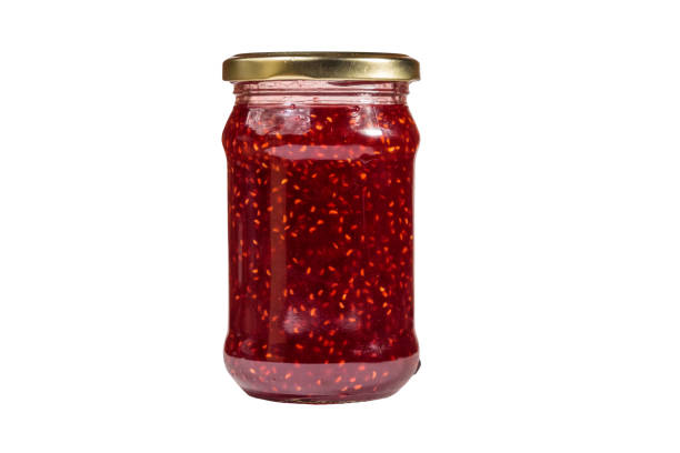 istock Raspberry jam in glass jar isolated on white background 1049501926