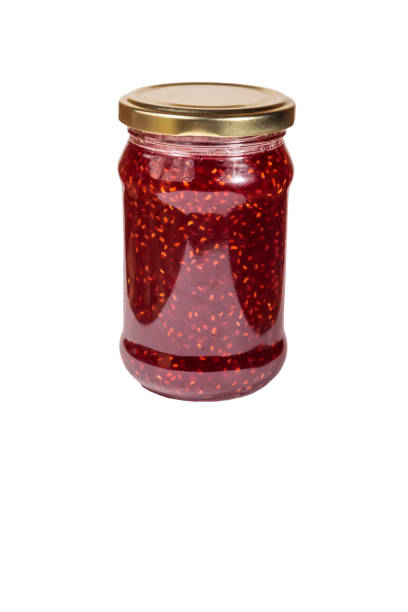 istock Raspberry jam in glass jar isolated on white background 1049501928